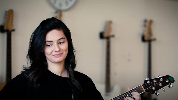 Kvinna spelar gitarr